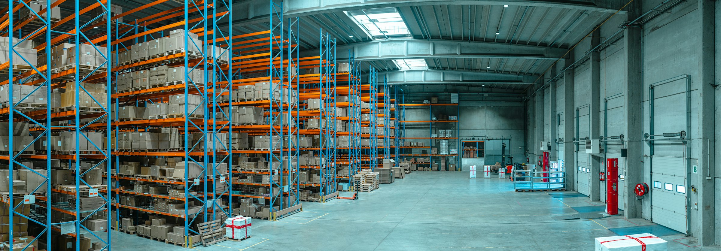 Distribution center with tall blue pallet racking and loading dock doors