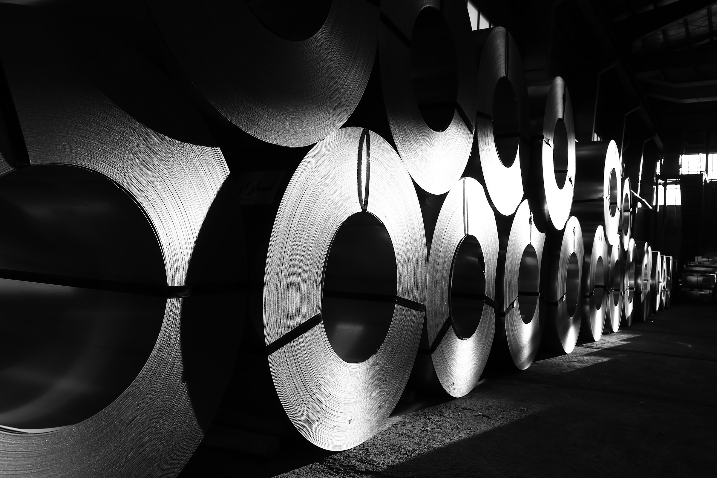 Rows of rolled steel coils in a distribution warehouse